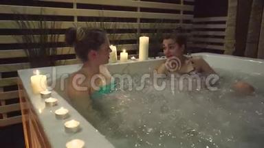 两个朋友在按摩浴缸里辛苦地休息了一天，在温泉中心泡泡。
